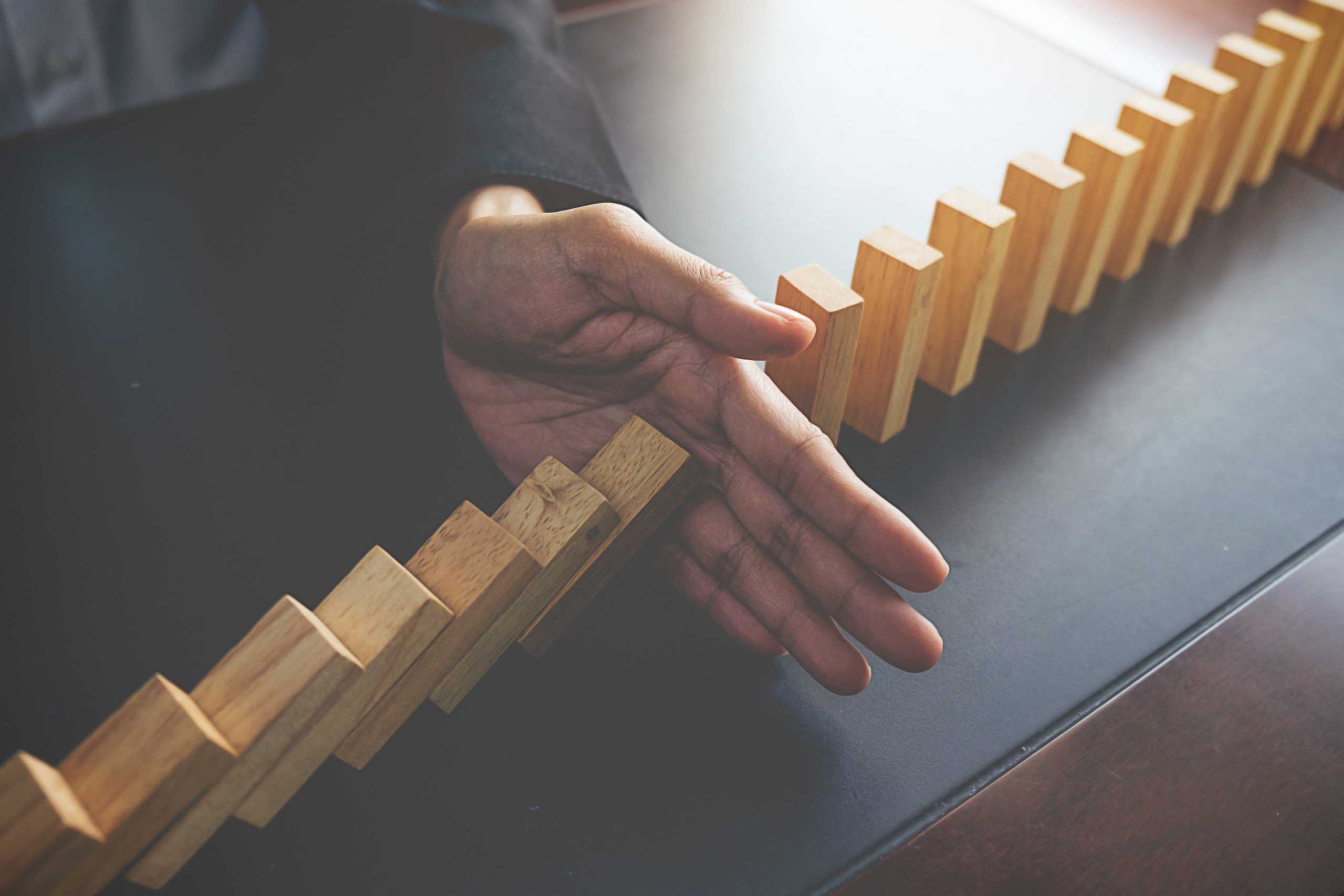 problem solving close up view hand business woman stopping falling blocks table concept about taking responsibility scaled - The Role of Quality Control in Wet Wipes Production